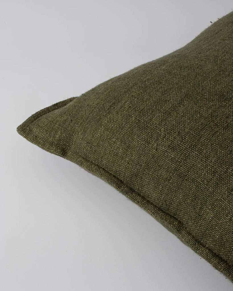 Close up of the Baya Flaxmill linen cushion with a flange edge, in colour moss green