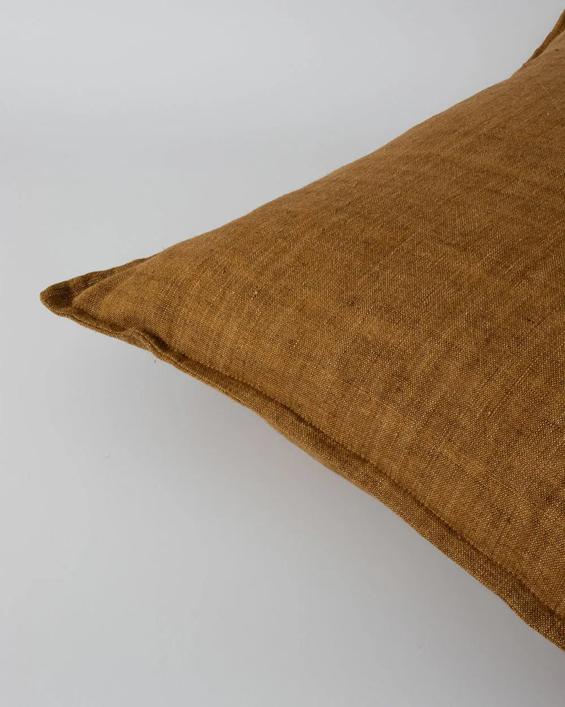 Close up of the Baya Cassia linen cushion, with flange detail, in colour tobacco brown