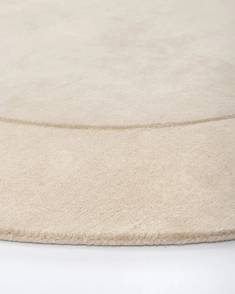 Edge detail of the Baya cream 'Form' curved floor rug