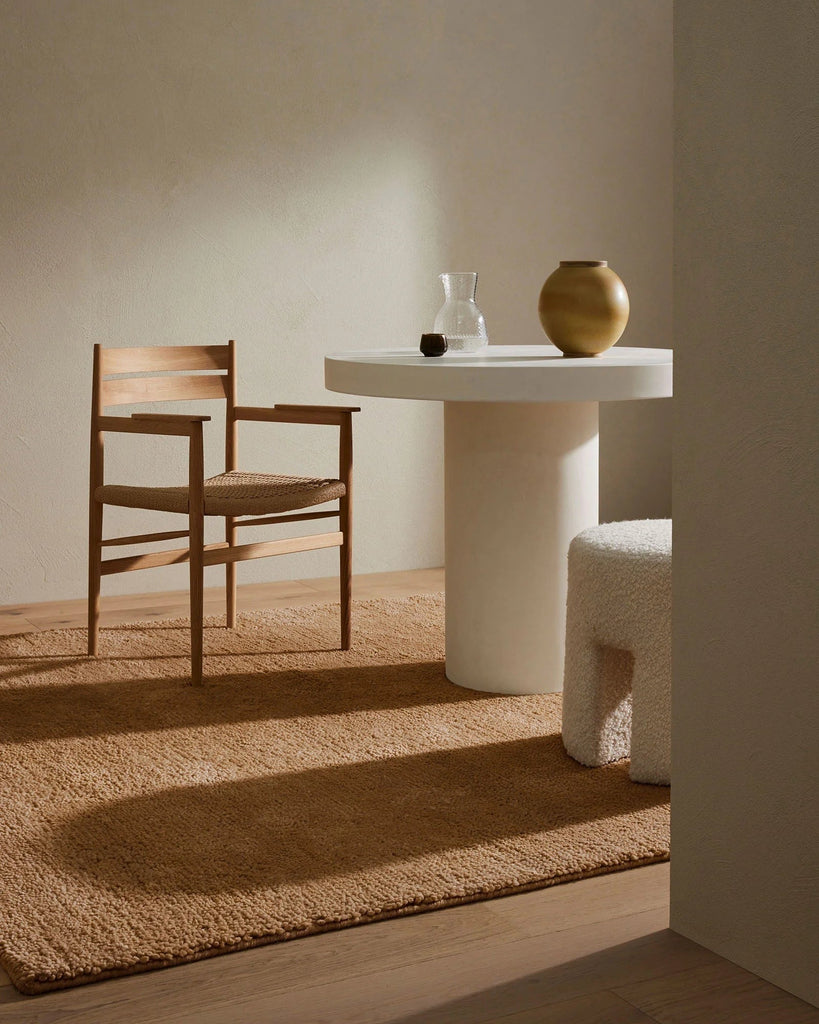 A rich caramel-brown wool rug, with thick and plush cut pile - the Valencia Camel, seen in a room with table and chairs