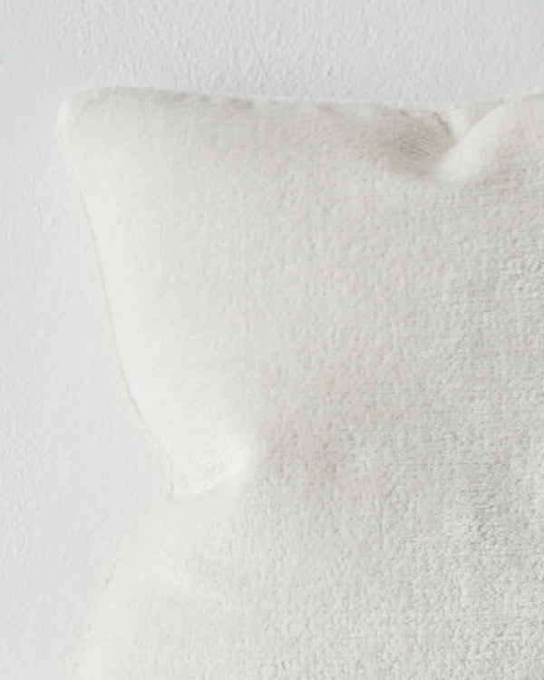 Close up of  a soft, white chenille cushion with piping - the Tempo Pearl by Weave