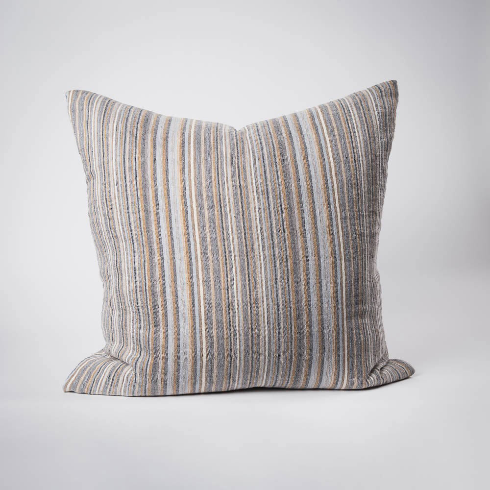A front on view of a large cushion with stripes in muted colours of ochre, slate, and red-brown. 