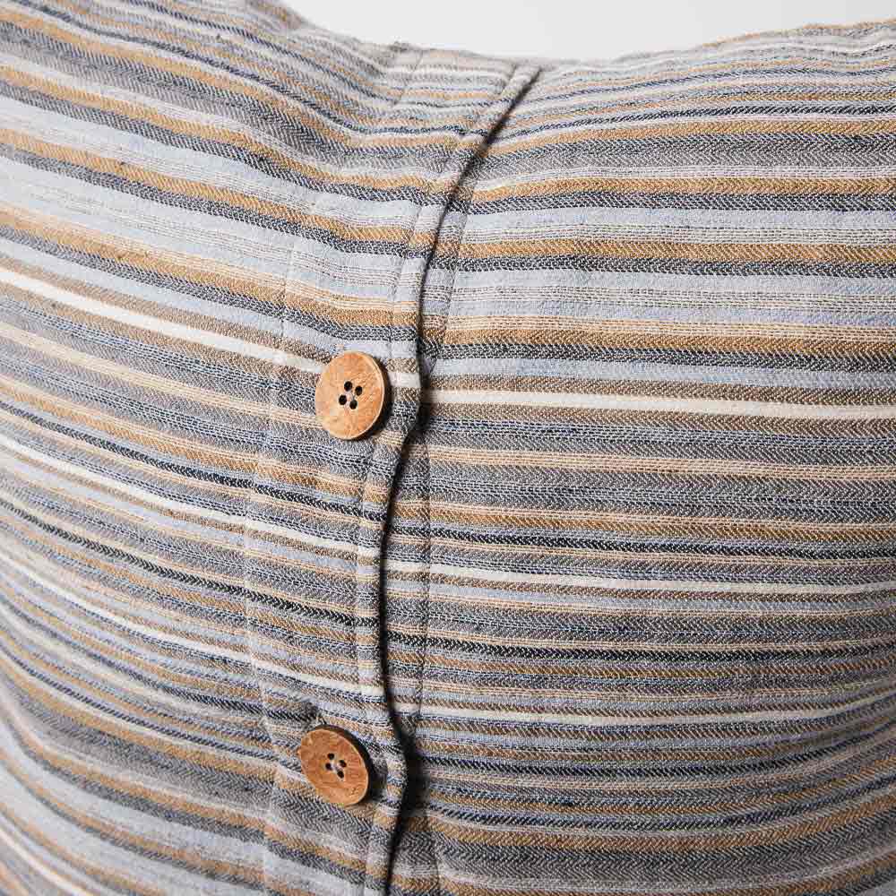 A close up view of the muted tones of the stripes in the Coast cushion cover, as well as the coconut buttons, a lovely feature. 