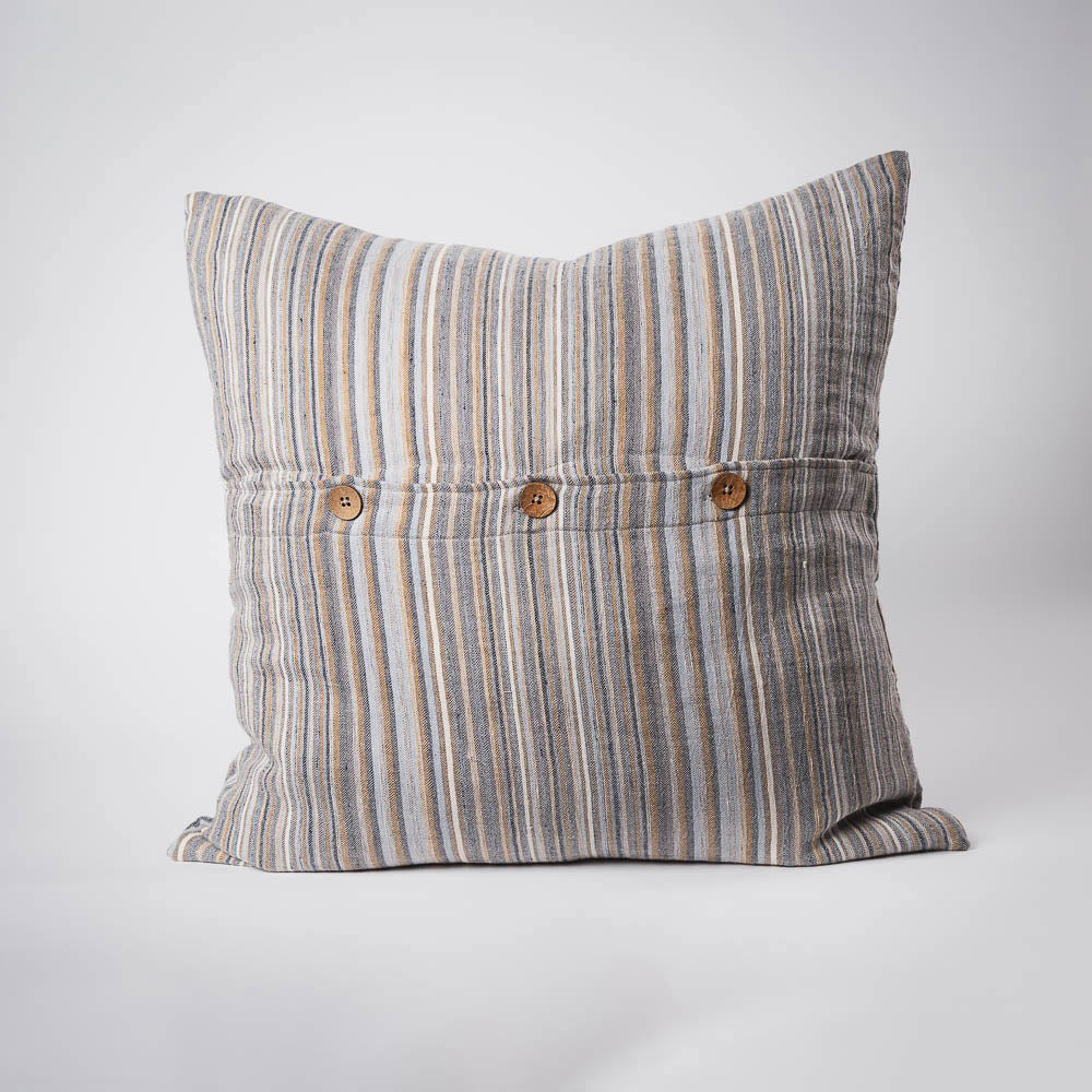 A front on view of a large cushion with stripes in muted colours of ochre, slate, and red. The front is closed with three wooden feature buttons. 