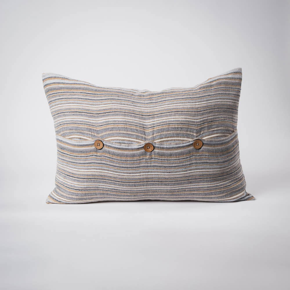 A front on view of a lumbar cushion with stripes in muted colours of ochre, slate, and red. The front is closed with three wooden feature buttons. 