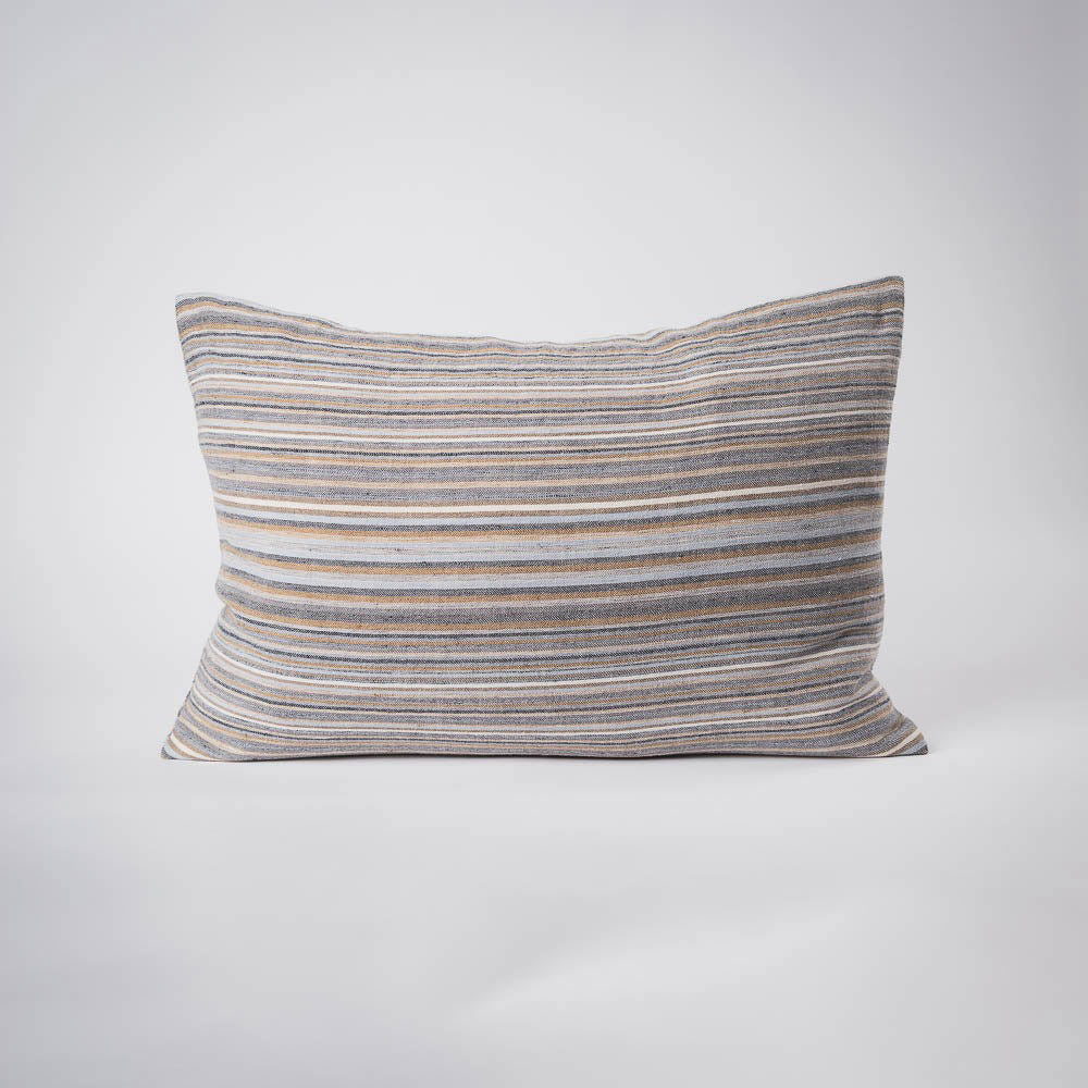 A front on view of a lumbar cushion with stripes in muted colours of ochre, slate, and red.