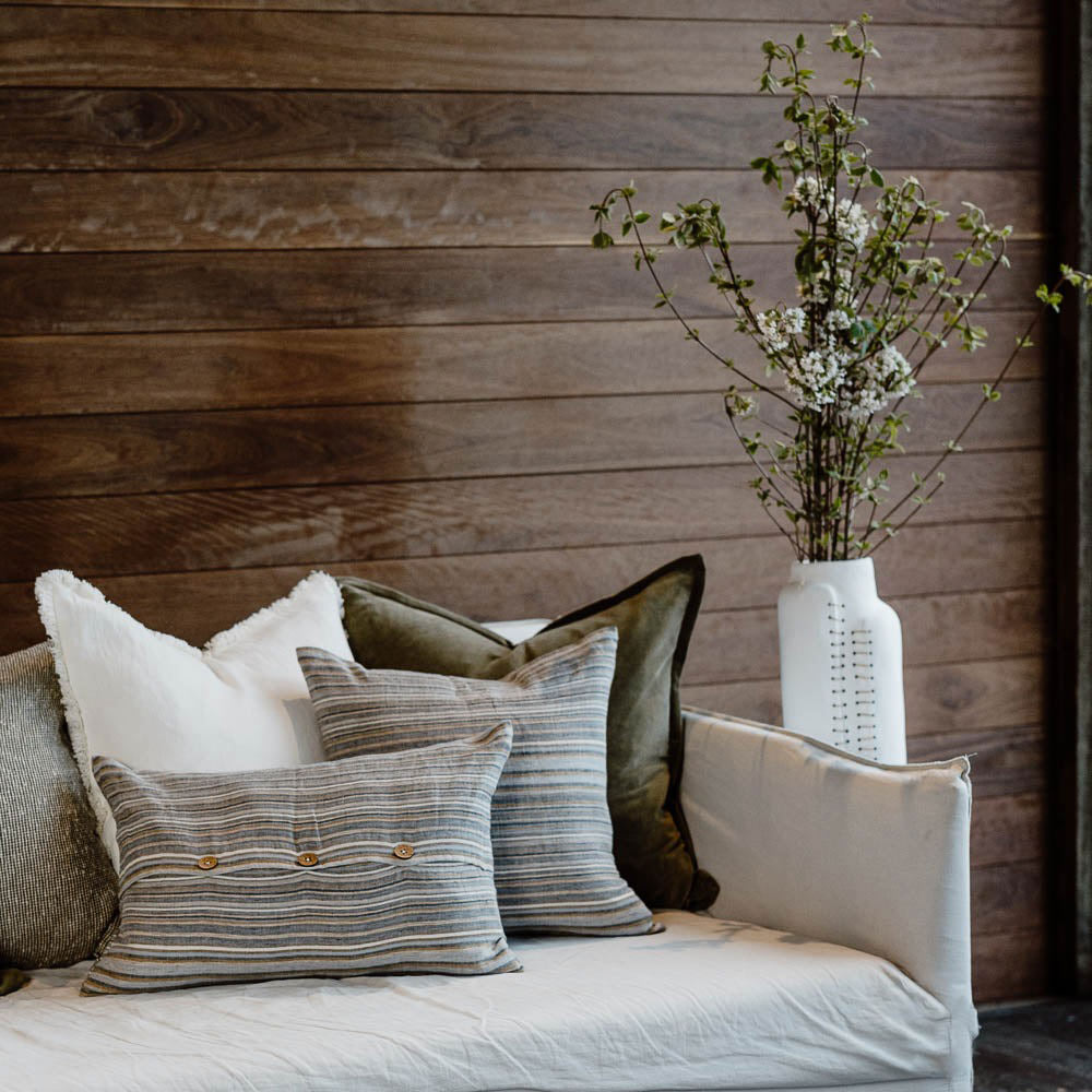 A stylish couch with cushions by Eadie, featuring lumbar and square cushions in Coast style. 