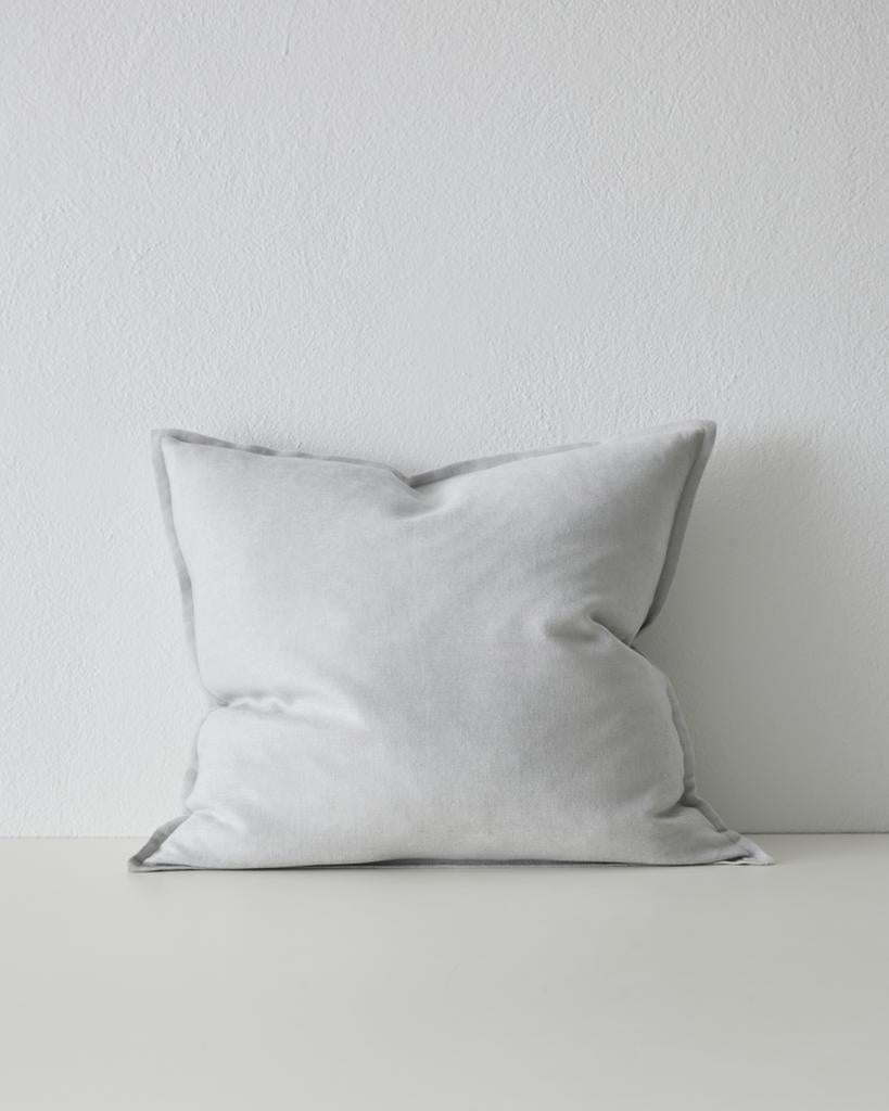 The Weave Home Fiore cushion in colour 'Glacier' - a pale blue-grey - with flange edge.