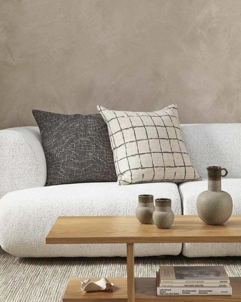 Dark chocolate coloured designer cushion by Baya NZ, seen on a couch in a modern nz living room.