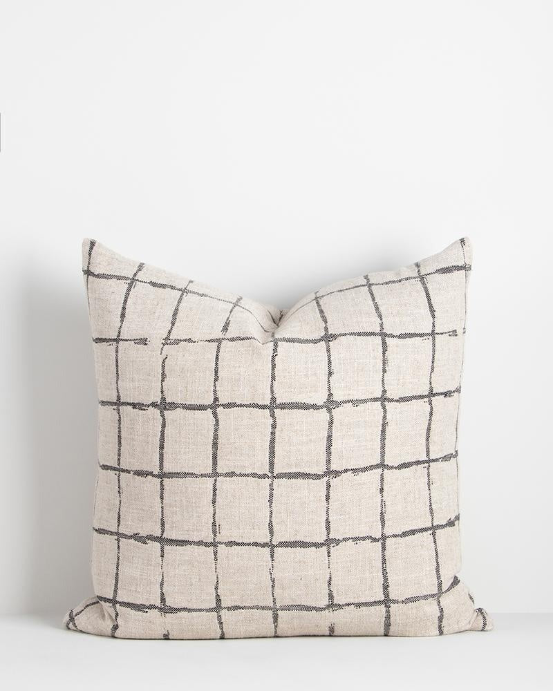 The Baya Harrison cushion in natural and black, featuring a black Japanese inspired grid-like design with a handcrafted look on a linen blend base.