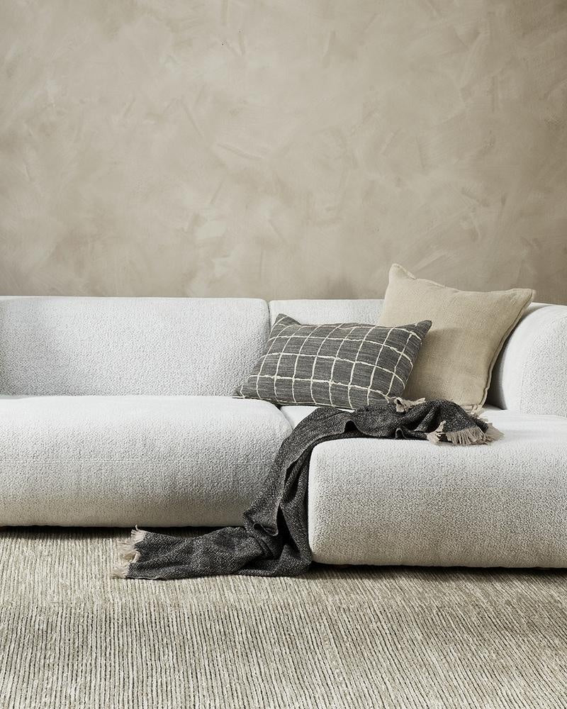 Baya Johnson and Flaxmill designer cushions on a couch in a stylish, modern living room.