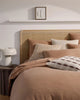 A bedroom featuring home decor by Weave home nz - cushions and linen bedding in warm colours