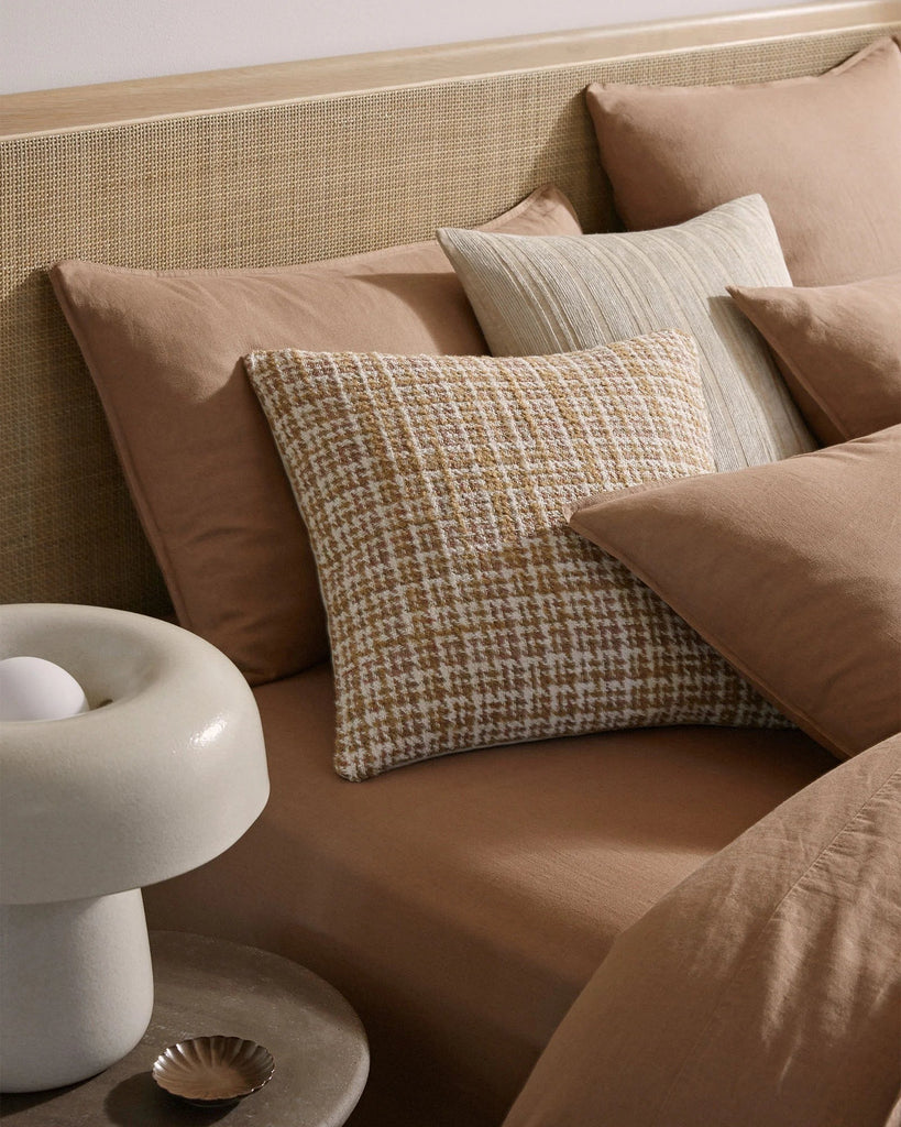 High quality linen bedding in an on-trend warm brown shade, with two feature cushions among the pillows, all by Weave nz