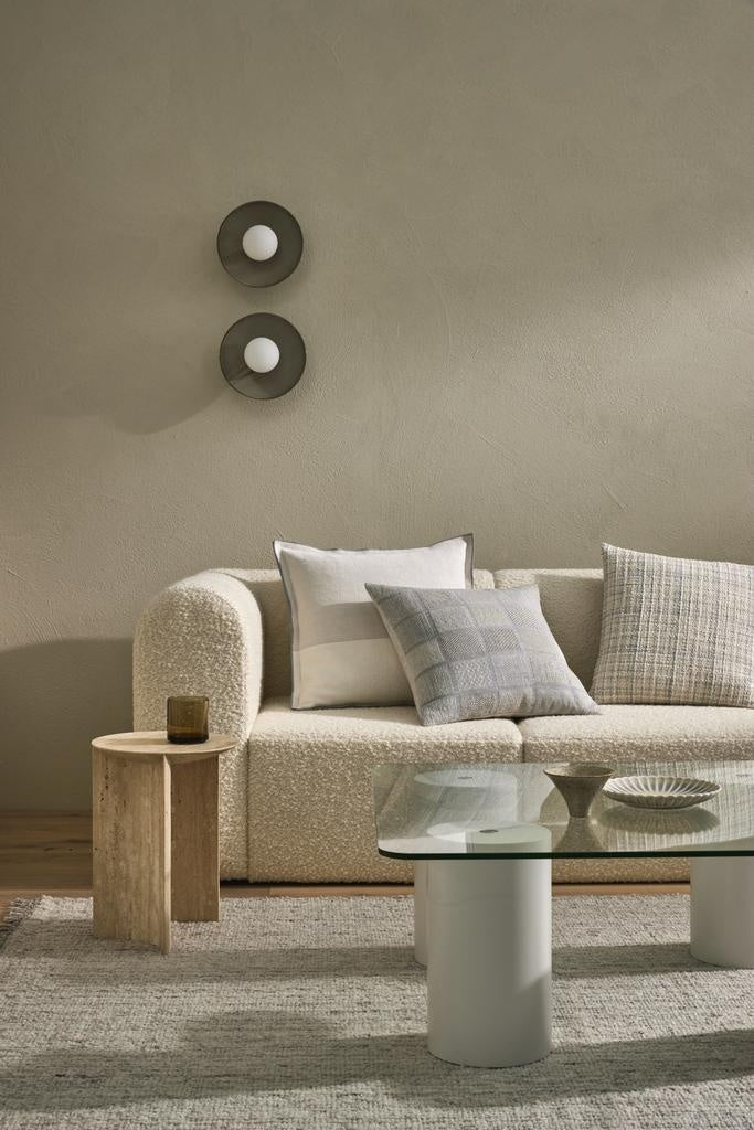 A neutral and stylish living room featuring Weave decor - a floor rug and three complementary cushions.