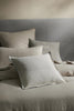 A bed with warm neutral tones, decorated with high quality cushions by Weave Home nz