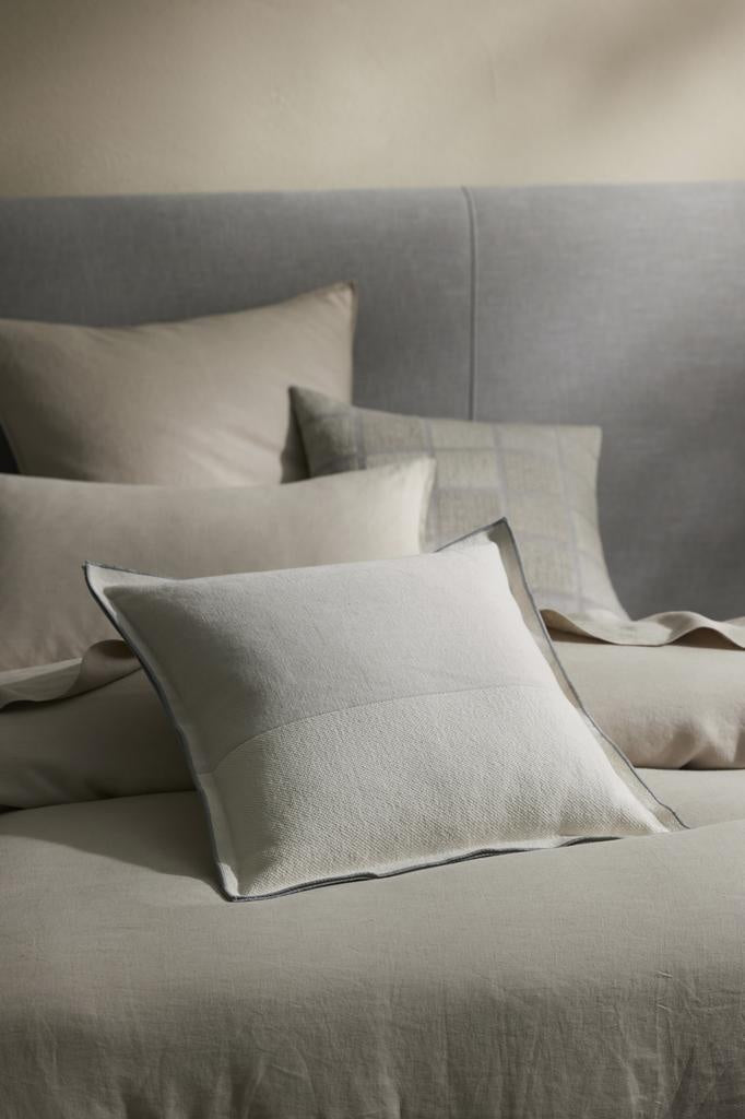 A bed with warm neutral tones, decorated with high quality cushions by Weave Home nz