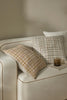 Feature cushions with a bold textural weave in warm colours and white, in a stylish home