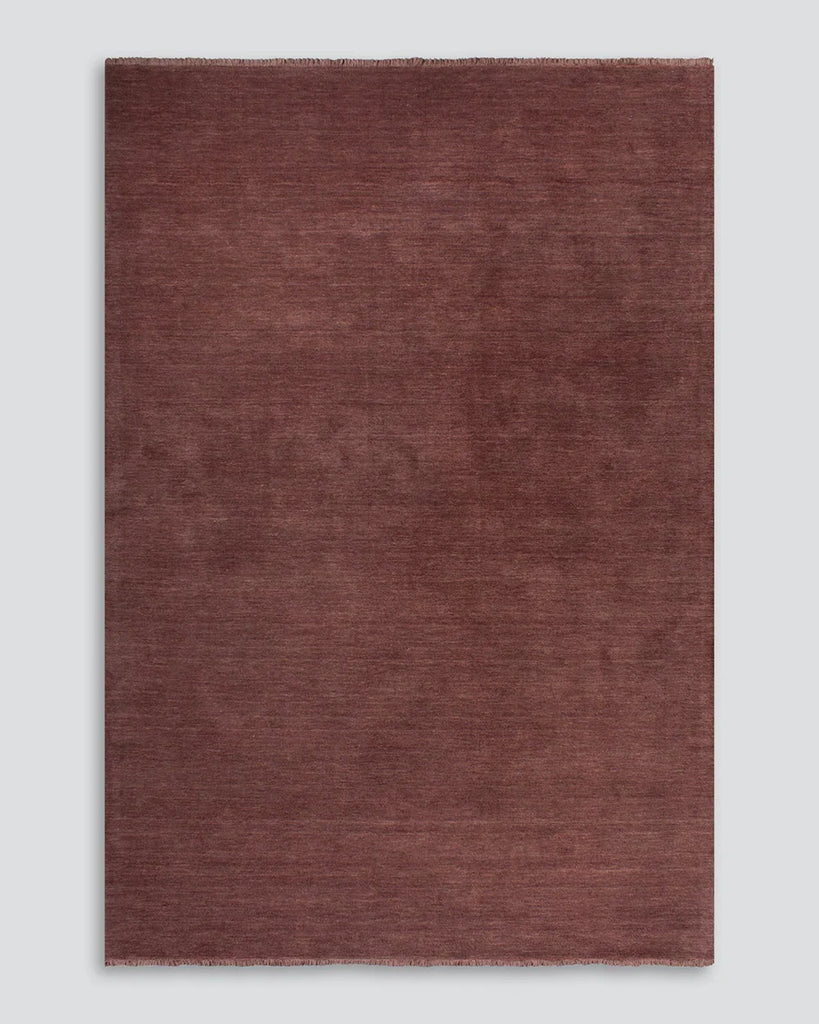 The Baya Sandringham wool floor rug with tasseled edge, in colour 'Merlot' red, from above