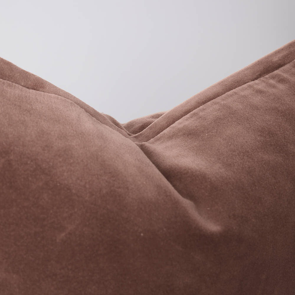 A detail image of a velvet long lumbar cushion, in a gorgeous muted dusky rose by Eadie Lifestyle