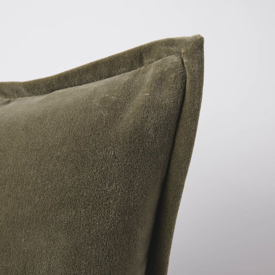 A corner image of a velvet long lumbar cushion, in a warm olive-green tone by Eadie Lifestyle