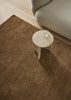 A brown, toffee-coloured wool rug with a thick, plush pile - the Valencia Toffee by Weave Home - seen from above under a coffee table.