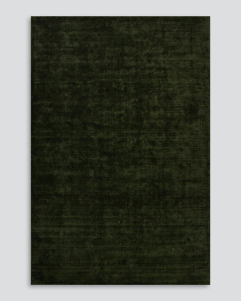 Full view from above of the deep green Haywood 'Caper' wool rug showing the sophisticated tip-shearing texture.