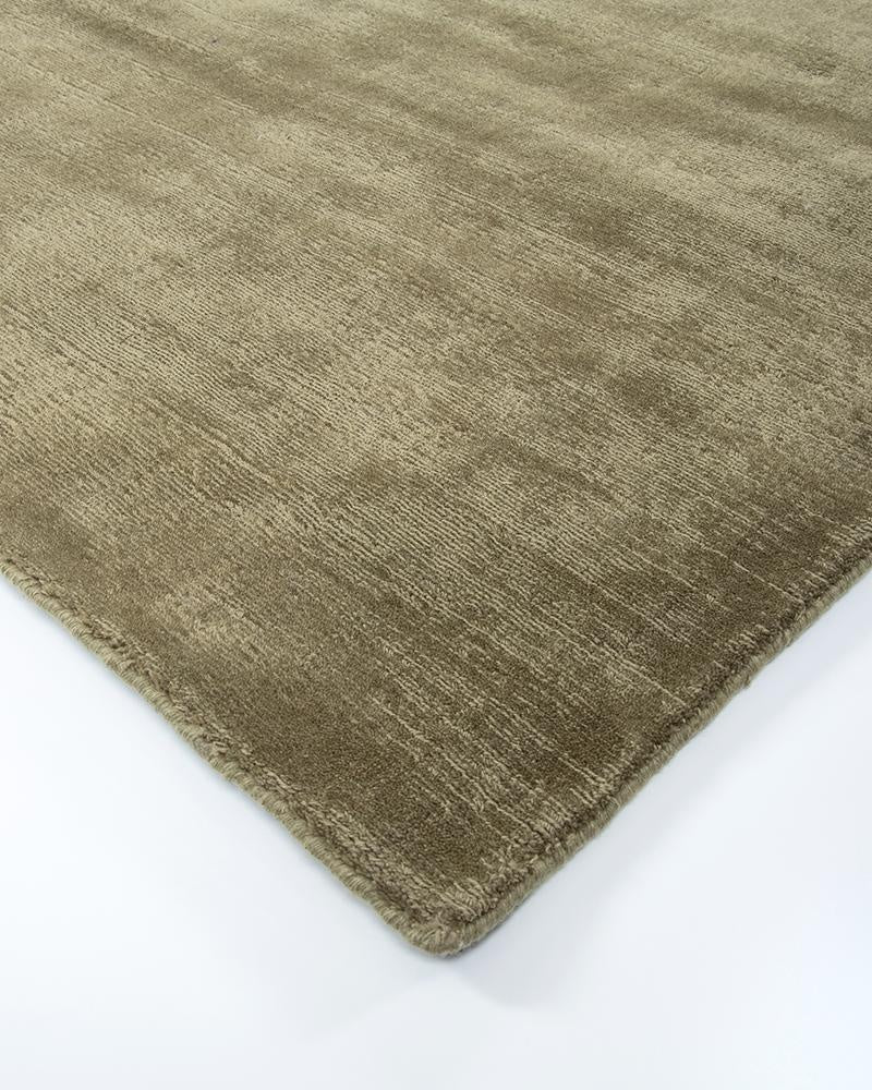 The exquisite Haywood green 'Lichen' New Zealand wool  floor rug seen from a corner in perspective  highlighting the tip sheared texture.