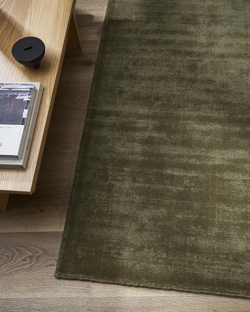 The exquisite Haywood green 'Lichen' New Zealand wool tip-sheared floor rug on wooden floor boards in a modern home