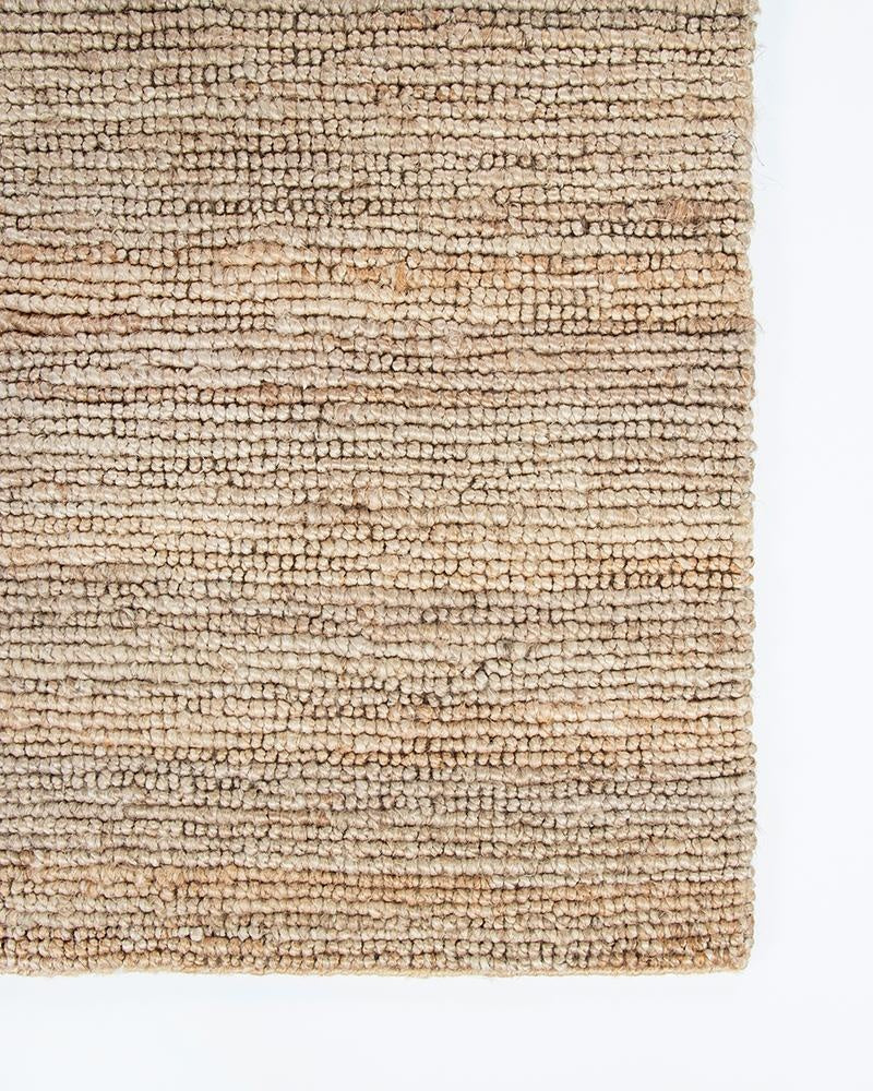 A corner of Baya's Papeete jute hallway runner rug, seen from above showing the stylish bobble weave