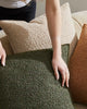 A lady placing Weave nz boucle cushions on a couch