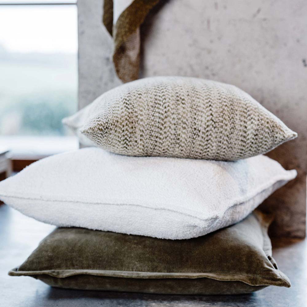 A pile of cushions in greens and whites with contrasting textures by Eadie Lifestyle 