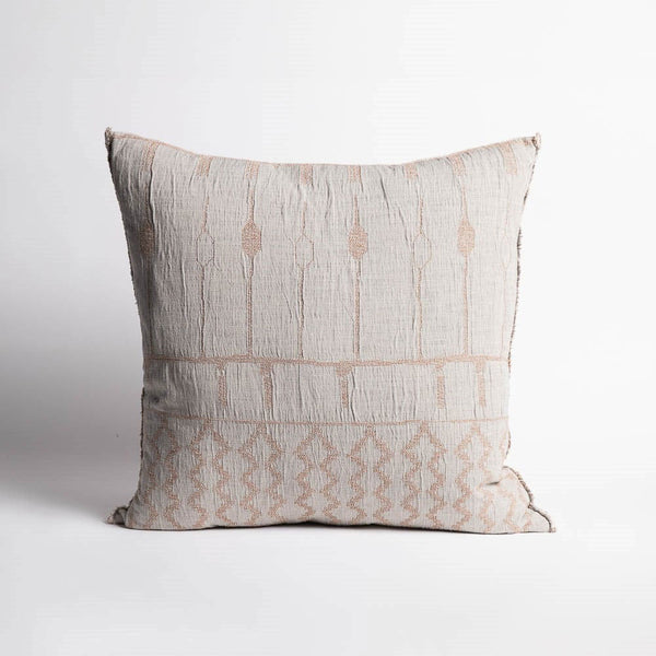 A large patterned cushion, with pale blue and soft clay tones in a reversible geometric pattern, and a softly fringed edge.