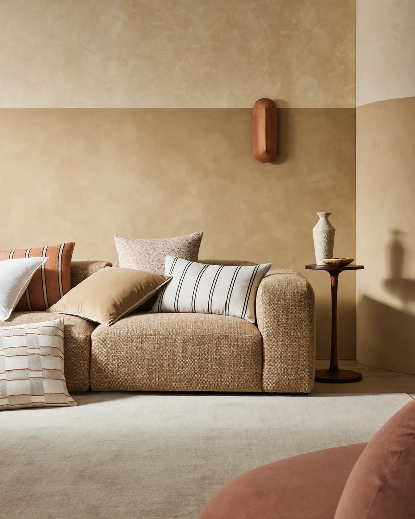 A modern warm brown lounge setting featuring Weave Home cushions