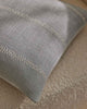 Pale blue cushions with white embroidered stripe on wool rug