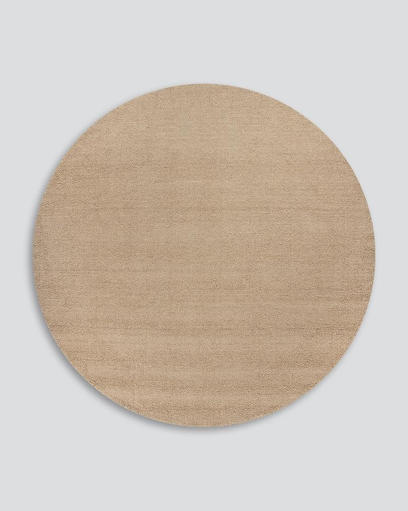 The round light-brown 'Biscuit' wool Dorset floor rug by Baya, seen from above