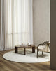 The round, Dorset, boucle weave wool and merino floor rug by Baya in a natural white seen in a modern living room