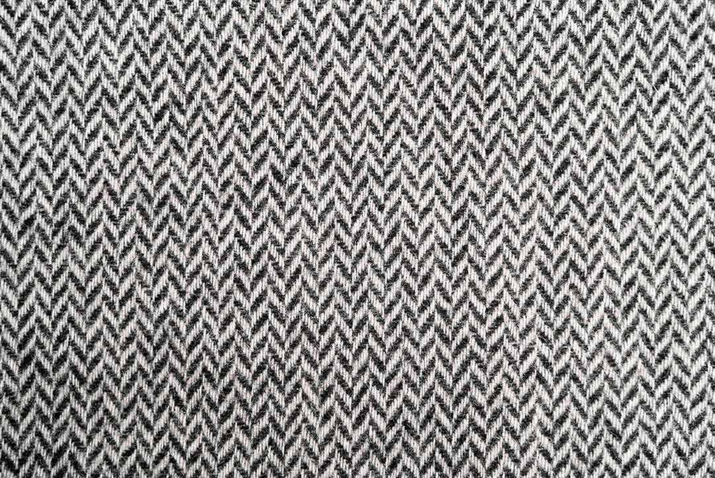 Close up of the Ruanui Station clooier's Coal chevron throw blanket in pure nz lambswool