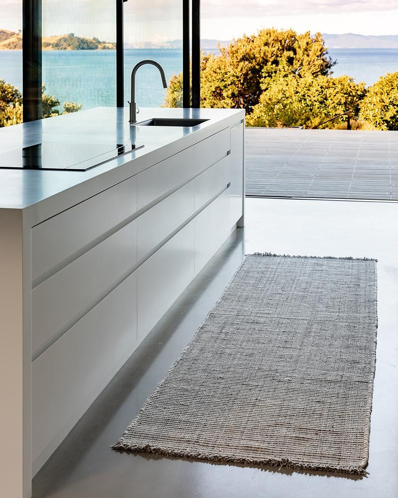 Slate grey floor runner rug seen on the floor of a kitchen in a stylish contemporary home