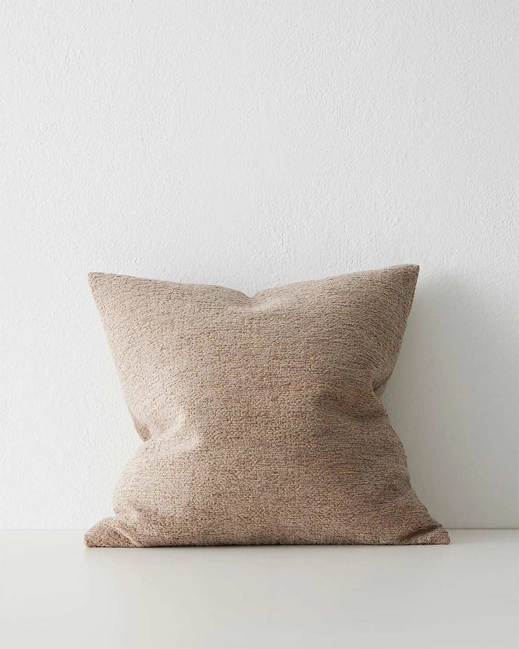 A softly textured light brown cushion. 