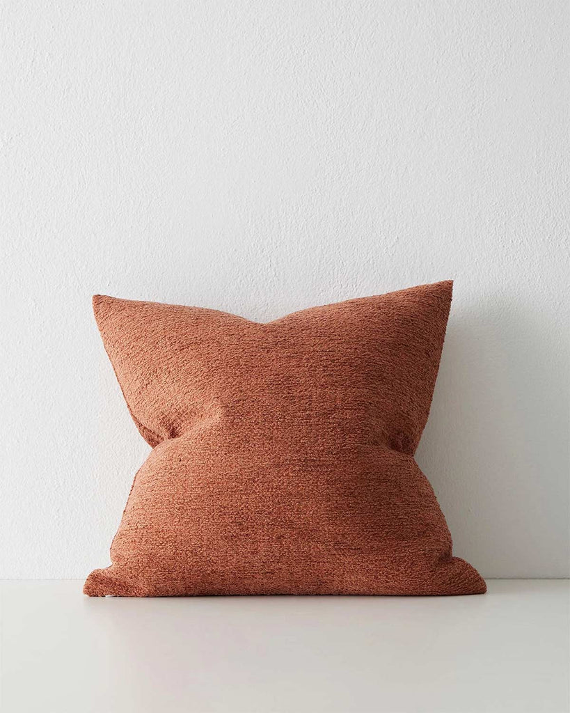 A textural cushion in a warm rust orange red tone. 