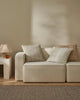 Three colours of the Tripoli cushion in warm whites and brown shades on a cream couch next to a brown rug