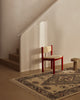 Tribe Home Ellora wool and jute rug at the foot of a staircase with a red chair