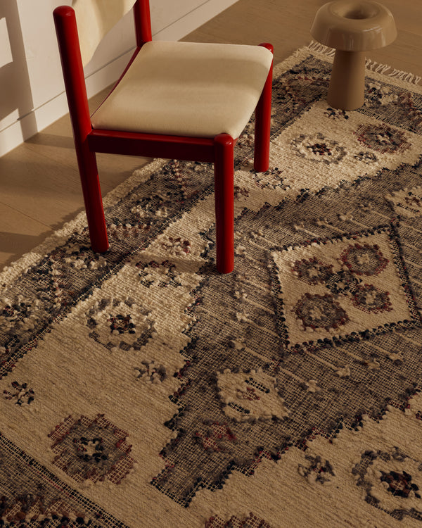 Close view of the Tribe Home Ellora wool and jute rug's diamond motif beside a red chair