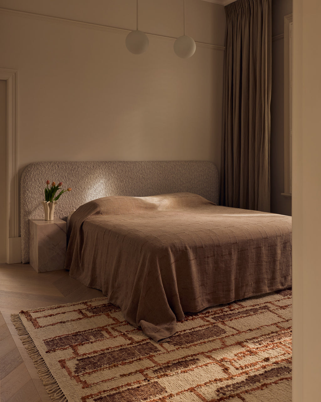 Tribe Home Rama wool and jute rug in Sienna beside a bed in a bedroom