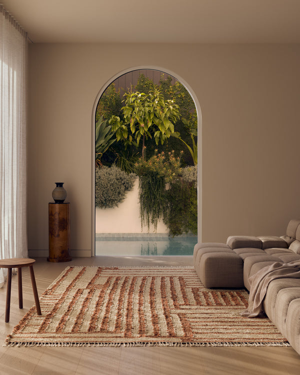 Tribe Home Tulsi wool and jute rug in Paprika in a living room with an arched window