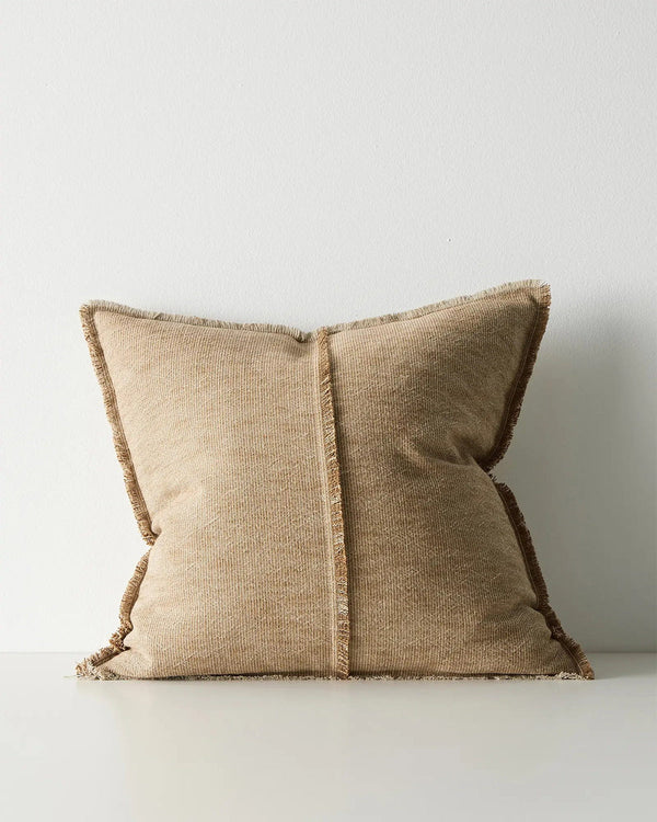Warm beige pillow with textured edges on a light gray background