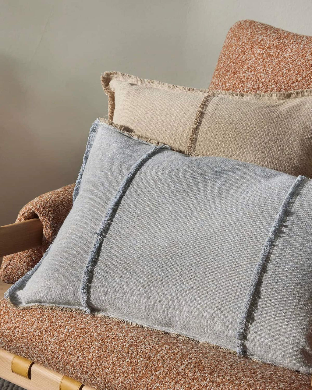 Gray pillow with textured edges on a textured armchair
