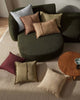 Green sofa with various colored cushions in a living room setting.