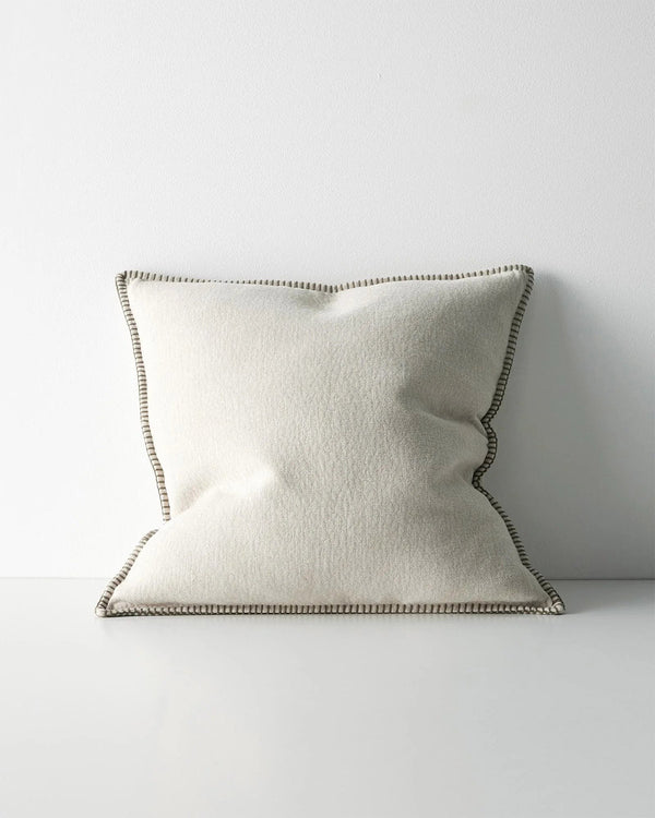 Beige pillow with an elegant stitch detail on a white background