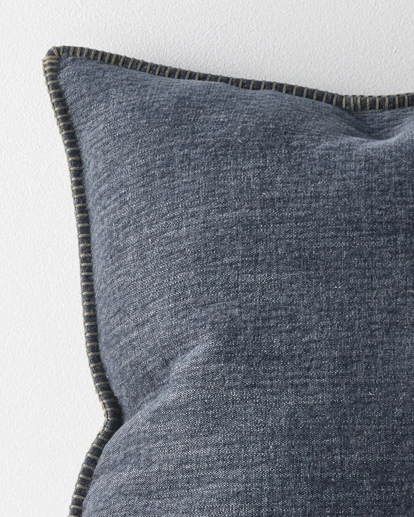 Close up corner of a designer cushion in blue with stitching detail